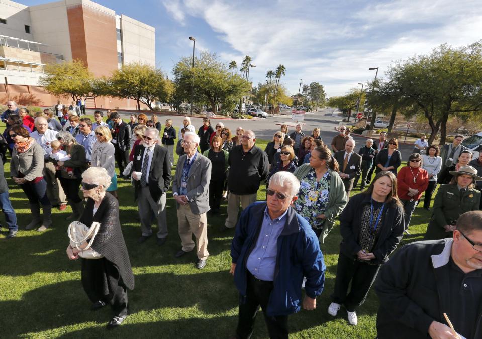 People assemble on the lawn outside University of Arizona Medical Center during a remembrance ceremony on the third anniversary of the Tucson shootings, Wednesday, Jan. 8, 2014, in Tucson, Ariz. Six people were killed and 13 wounded, including U.S. Rep. Gabrielle Giffords, D-Ariz., in the shooting rampage at a community event hosted by Giffords. The victims were all transported to the medical center in 2011. Jared Lee Loughner was sentenced in November 2012 to seven consecutive life sentences, plus 140 years, after he pleaded guilty to 19 federal charges in the shooting. (AP Photo/Matt York)