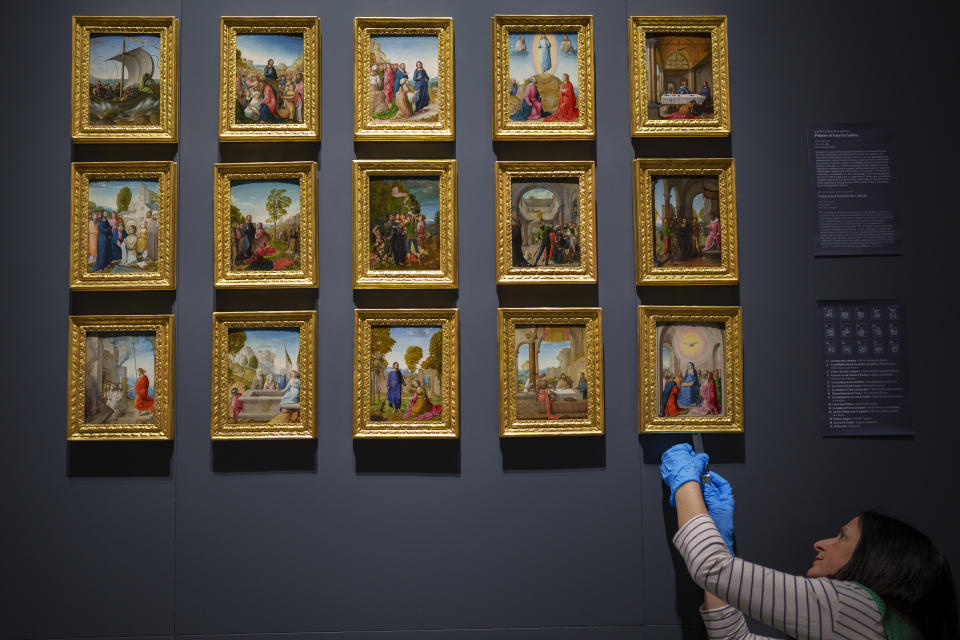 A staff member of the museum sets up the work "Polyptych Isabel Catolica", at the Royal Collections Gallery in Madrid, Spain, Friday, May. 19, 2023. Spain is set to unveil what is touted as one of Europe’s cultural highlights of the year with the opening in Madrid of The Royal Collections Gallery next month. (AP Photo/Manu Fernandez)