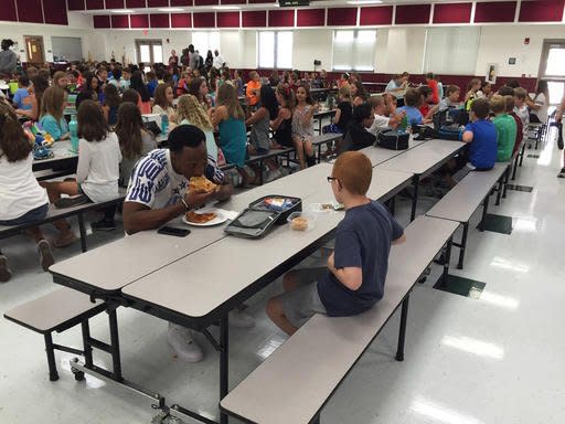 In this Tuesday, Aug, 30, 2016 photo provided by Michael Halligan, Florida State University wide receiver Travis Rudolph has lunch with Bo Paske at Montford Middle School in Tallahassee, Fla. A small gesture of kindness by Rudolph sent tears streaming down the face of the sixth-grader's mother, Leah Paske, who shared her gratitude on Facebook Tuesday afternoon after seeing a picture of Rudolph sharing lunch with her son Bo in his middle school cafeteria. (Michael Halligan via AP)