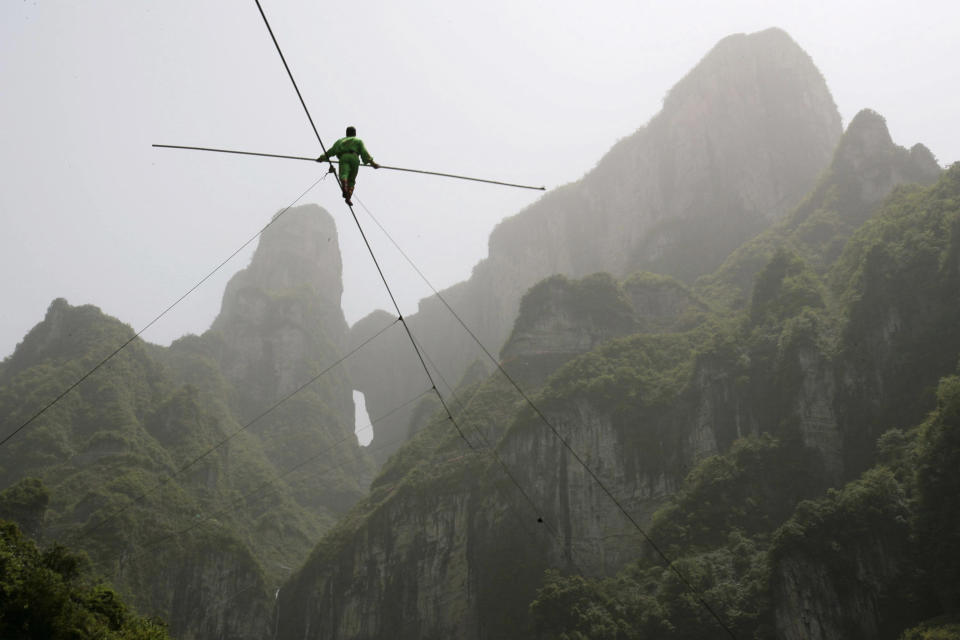 Samat Hasan, a 24-year-old stuntman from Xinjiang Uighur Autonomous Region, walks on a tightrope in Zhangjiajie, Hunan province April 25, 2009. Walking on a 700-metre-long (2,300 ft) rope with a 3.1-centimetre (1.2 inches) diameter and set at a 39-degree gradient, Hasan successfully broke the Guinness World Record for aerial tightrope walking after failing in a previous attempt in October last year, local media reported. REUTERS/China Daily