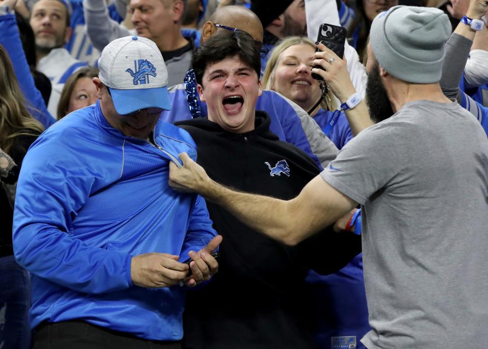 Fans grab one another and scream after the Detroit Lions 24-23 win over the Los Angeles Rams in their first playoff game at Ford Field against the Los Angeles Rams in Detroit on Sunday, Jan. 14, 2024.
