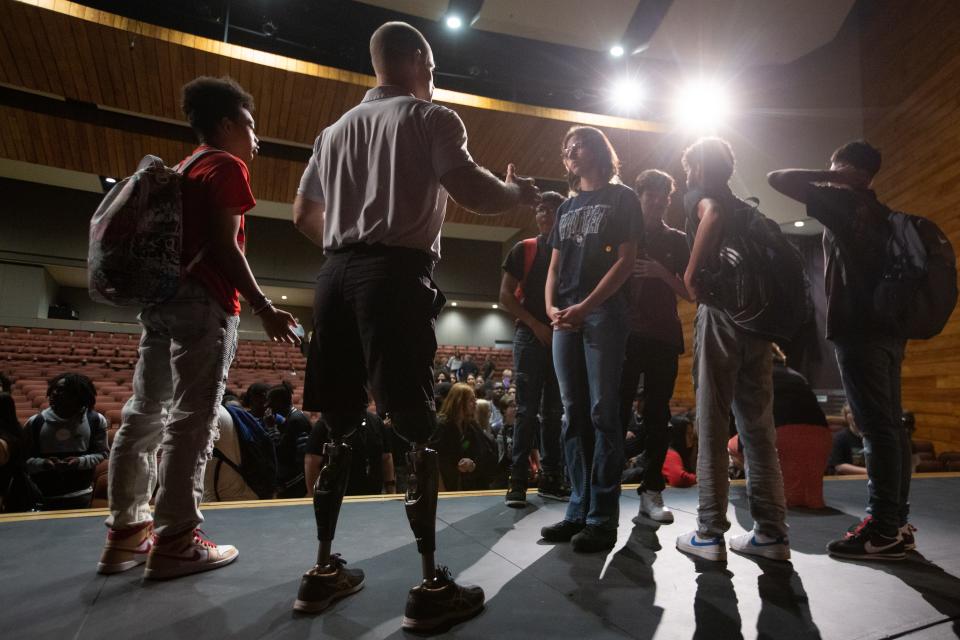 A crowd of curious high schoolers from area schools take turns talking one-on-one with Dan Cnossen following his presentation at Shawnee Heights.