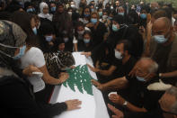 Relatives of Lebanese army lieutenant Ayman Noureddine, who was killed by Tuesday's explosion that hit the seaport of Beirut, mourn over his coffin during his funeral procession, in Numeiriyeh village, south Lebanon, Friday, Aug. 7, 2020. Rescue teams were still searching the rubble of Beirut's port for bodies on Friday, nearly three days after a massive explosion sent a wave of destruction through Lebanon's capital. (AP Photo/Mohammed Zaatari)