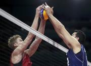 <p>Maxwell Holt (USA) of USA and captain Emanuele Birarelli (ITA) of Italy hold onto the ball. (Reuters) </p>