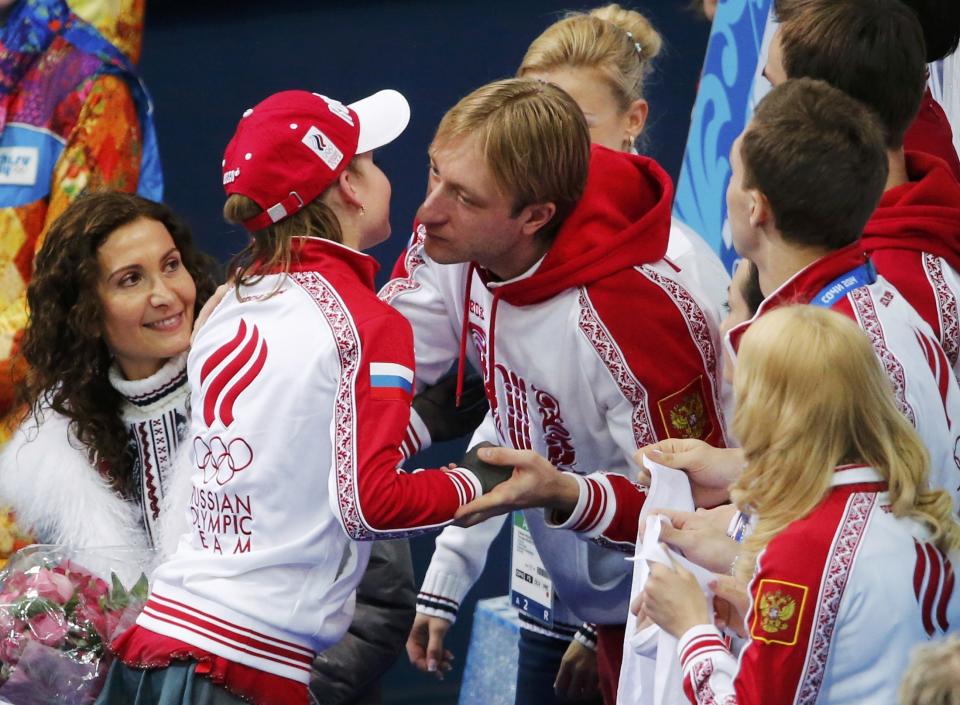 Yulia Lipnitskaya of Russia is greeted by Evgeny Plyushchenko in the "kiss and cry" area during the Team Ladies Free Skating Program at the Sochi 2014 Winter Olympics, February 9, 2014. REUTERS/David Gray (RUSSIA - Tags: SPORT FIGURE SKATING SPORT OLYMPICS)