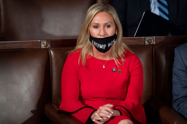 Pictured on the day of her swearing-in ceremony on Jan. 3, 2021, Marjorie Taylor Greene attempts to wear a face mask reading, “TRUMP WON.” Trump had, in fact, lost. (Photo: Caroline Brehman via Getty Images)