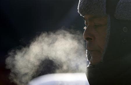 A man reacts on another day of frigid temperatures as he walks through downtown Chicago, Illinois, January 8, 2014. REUTERS/Jim Young