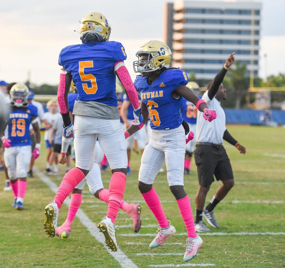 Cardinal Newman players Vinkevus Pierre (5) and Dallas DeSouza (6) celebrate a touchdown during a 40-7 victory over John Carroll Monday night in West Palm Beach.