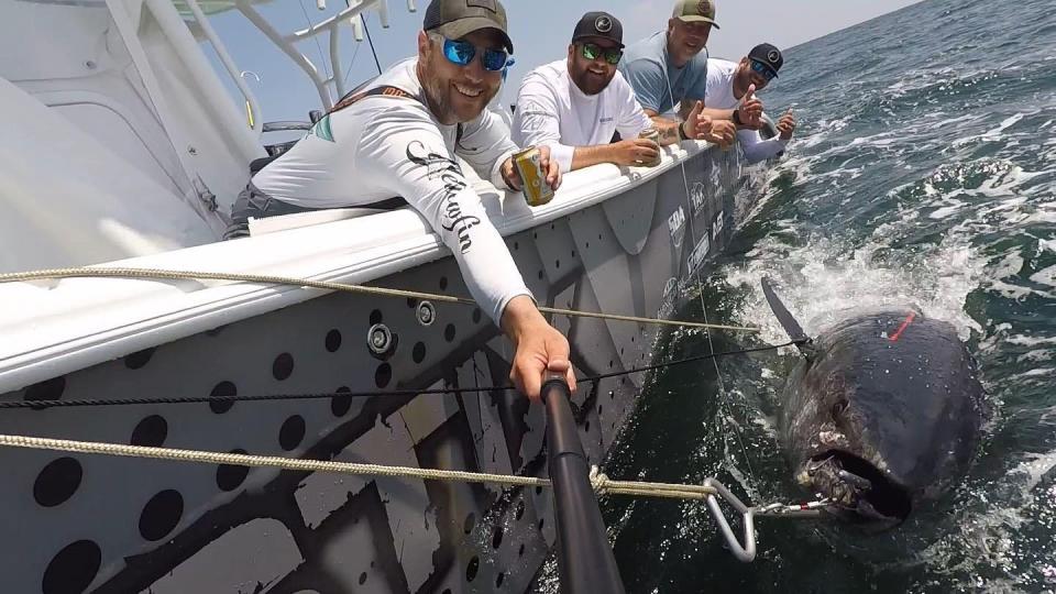 The Fish Stix crew, from left, Ian Bonham, Capt. Kris Black, Jeff Paetzold and Bill Young, with a giant bluefin tuna boat side.
