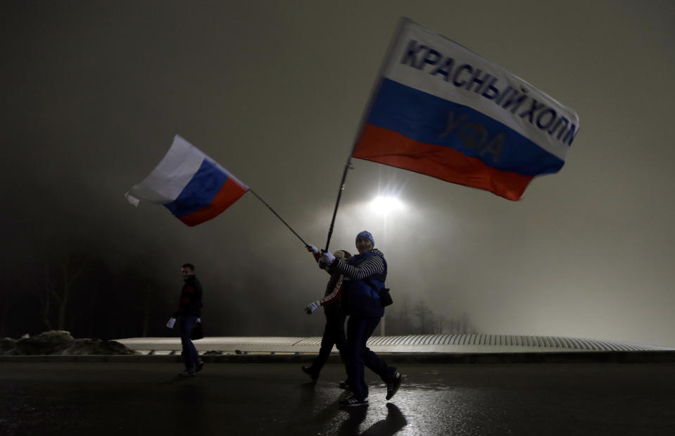 Russian fans walk through Sanki Sliding Center in the fog during the men's two-man bobsled competition at the 2014 Winter Olympics, Sunday, Feb. 16, 2014, in Krasnaya Polyana, Russia. (AP Photo/Natacha Pisarenko)