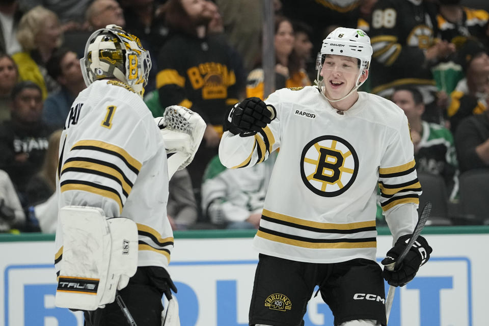 Boston Bruins defenseman Mason Lohrei, right, celebrates his first period goal with goaltender Jeremy Swayman during an NHL hockey game against the Dallas Stars, Monday, Nov. 6, 2023, in Dallas. (AP Photo/Julio Cortez)