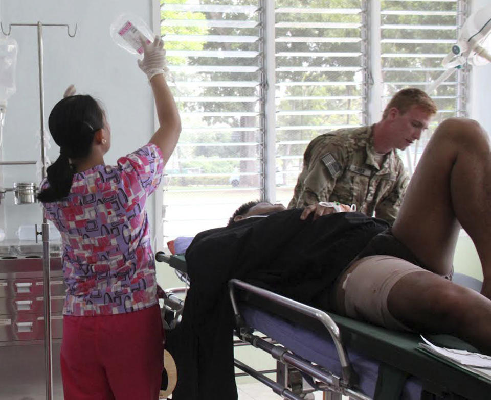 Doctors treat an victim injured in a bombing, at a military hospital after being airlifted from the site of an improvised explosive devise explosion Saturday, Feb. 1, 2014 at Datu Saudi Ampatuan township, Maguindanao province in southern Philippines. A homemade bomb that was likely set off by Muslim rebels in the southern Philippines on Saturday wounded 12 people, including six soldiers and two television journalists, the military said. The blast happened near an area where government troops have been battling Muslim insurgents who broke away from a larger rebel group after it signed a peace deal with the government. (AP Photo)