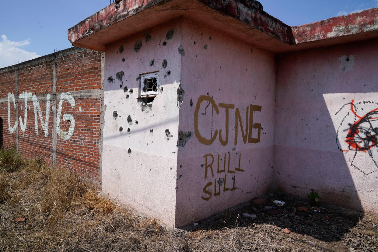 The letters CJNG, for the group's formal name, Jalisco New Generation Cartel, are scrawled on the facade of an abandoned home in El Limoncito, in the Michoacan state of Mexico, Saturday, Oct. 30, 2021.