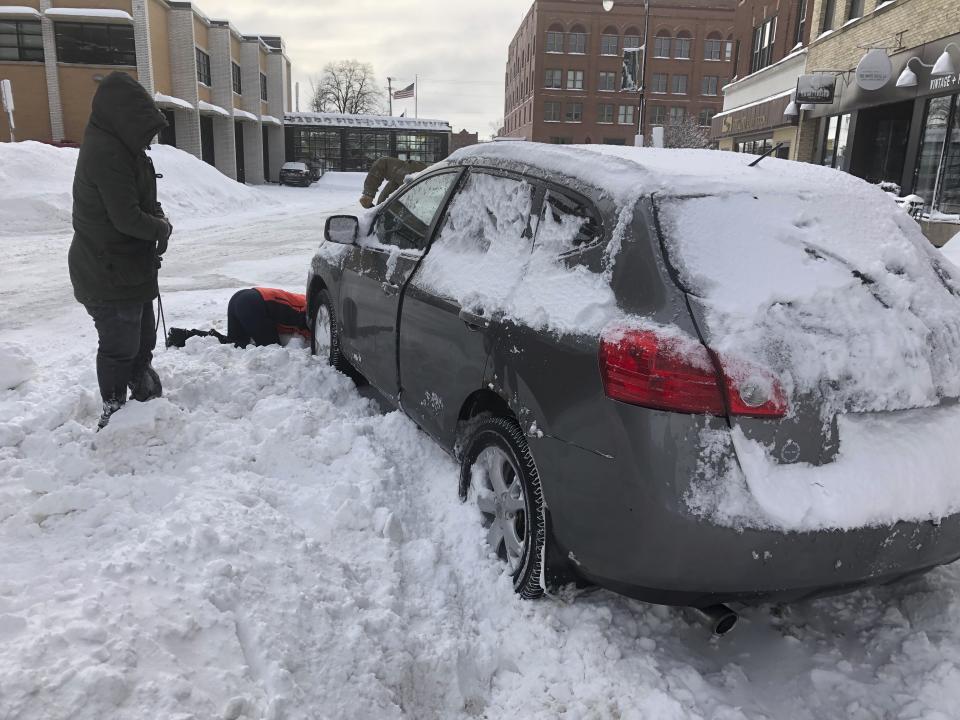 Volunteers help a woman dig out her parked car on Monday, Dec. 30, 2019, after it was blocked by snow from a plow that was clearing snow in downtown Fargo, N.D., after a blizzard that dumped a foot or snow in some areas of the metropolitan area. Authorities warned residents on Saturday to get their cars off the street to help cleaning crews in a process they say could take weeks to complete. Most businesses in the Fargo and Moorhead, Minnesota area were closed or open late on Monday. (AP Photo/Dave Kolpack)
