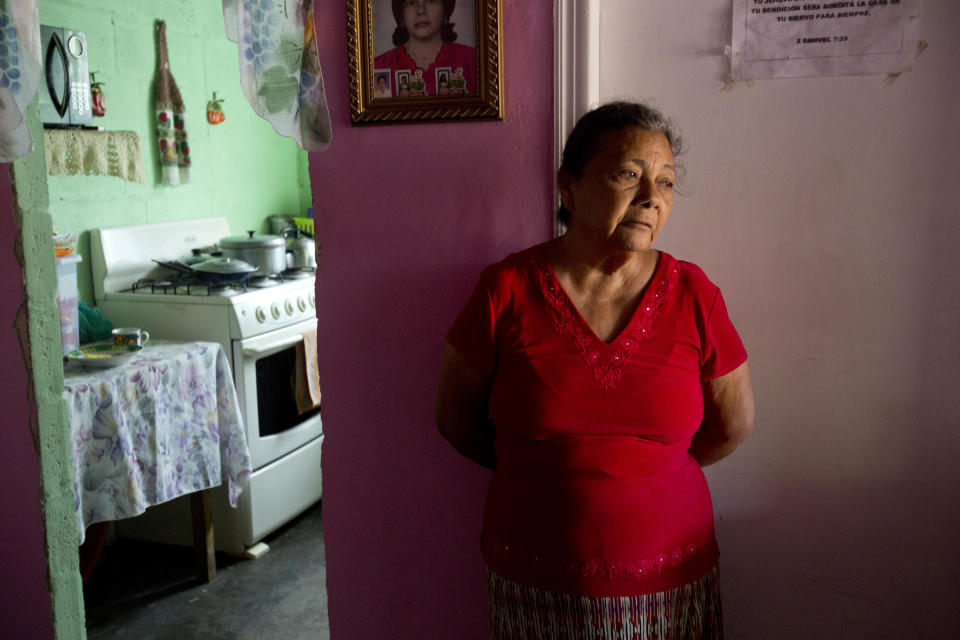 In this Nov. 3, 2018 photo, Haydee Posadas leans against a wall inside her home in Ciudad Planeta neighborhood of San Pedro Sula, Honduras. Posadas has a mantra for survival in Planeta: "If you saw it, you didn't see it. If you heard it, you didn't hear it. And everyone keeps quiet." (AP Photo/Moises Castillo)