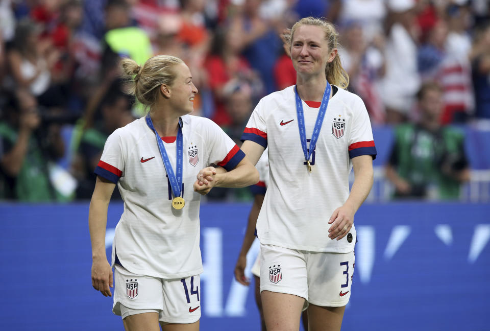 FILE - United States' Emily Sonnett, left and Samantha Mewis celebrate their 2-0 victory in the Women's World Cup soccer final match against Netherlands at the Stade de Lyon in Decines, outside Lyon, France, Sunday, July 7, 2019. Samantha Mewis, who played for the U.S. team that won the 2019 Women's World Cup, has retired from soccer because of a knee injury that has sidelined her from the national team since the Tokyo Olympics.(AP Photo/David Vincent, File)