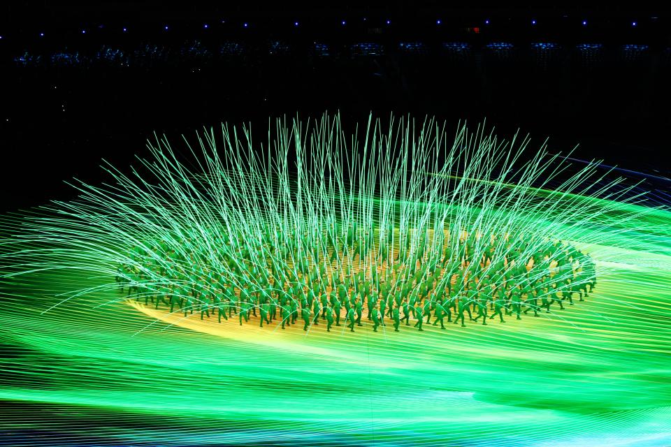 Performers create a flower display with LED lights (Getty Images)