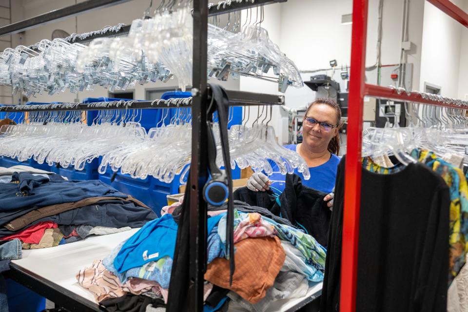 A Goodwill worker sorts and prices donated clothes to be put in the Eustis retail store.