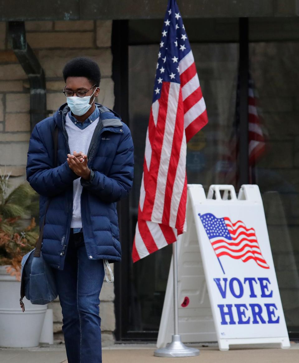 Lawrence University student Malcom Davis sanitizes his hands after voting during the Wisconsin primaries at Memorial Presbyterian Church, April 7, 2020, in Appleton, Wisc.