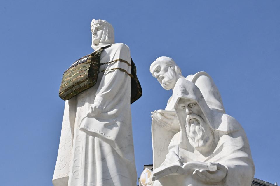 The Princess Olga monument in Kyiv is dressed in a dummy bulletproof vest with a sign reading "She needs armor" to draw attention to the need of armor designed specifically for women on Sept. 25, 2023.