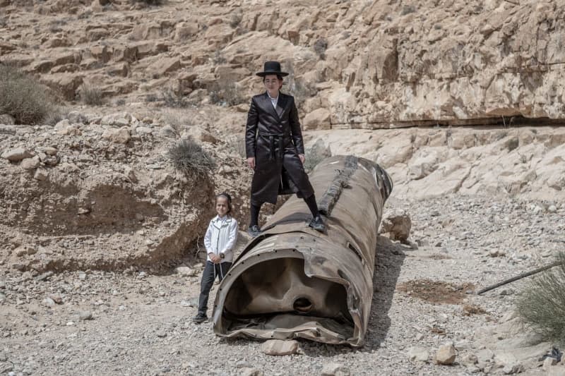 An Israeli Orthodox Jew stands on a part of an Iranian rocket that was left in the desert near southern Israeli city of Arad. Ilia Yefimovich/dpa