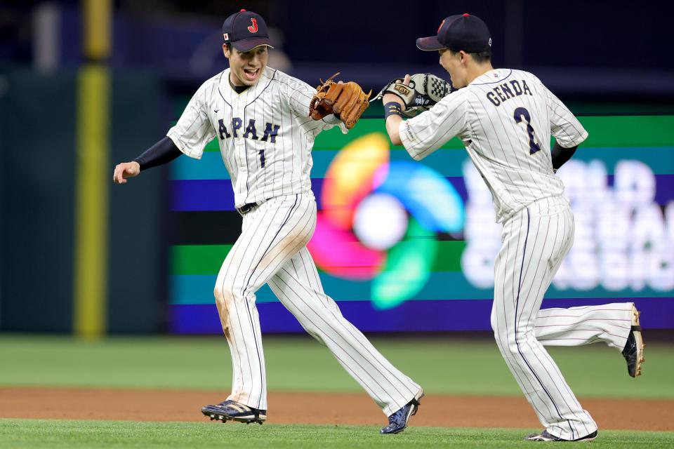 Tetsuto Yamada and Sosuke Genda celebrate the final out of the seventh inning.