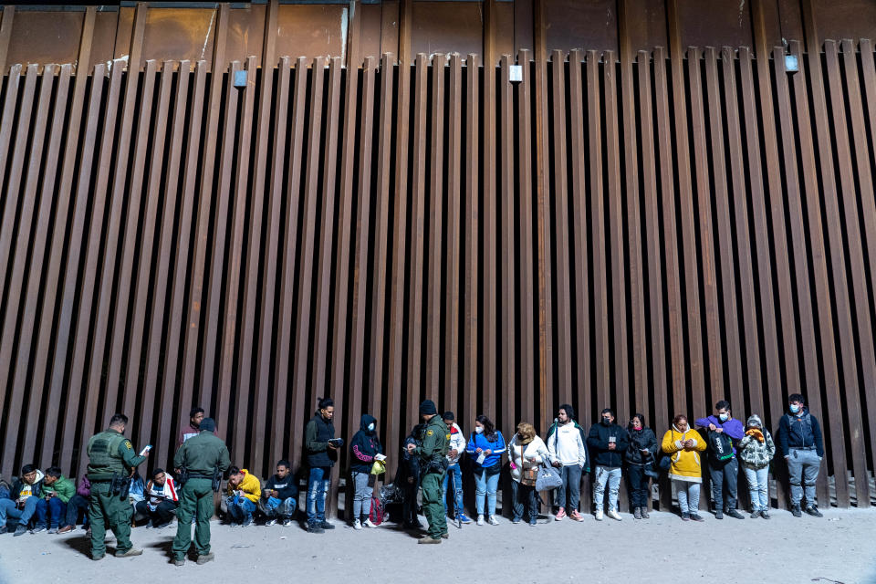 Migrants and asylum seekers are detained by U.S. Border Patrol agents after crossing the U.S.-Mexico border in Yuma County, near the Cocopah Indian Tribe's reservation on Dec. 8, 2022. Border Patrol agents estimated the group to be about 700 people.