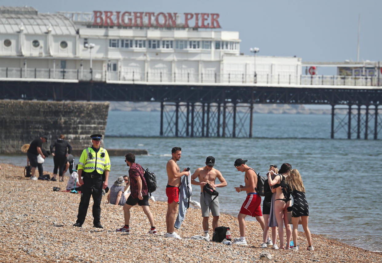 A police officer advises a group of people to move from Brighton Beach in East Sussex as the UK continues in lockdown to help curb the spread of the coronavirus. (Photo by Gareth Fuller/PA Images via Getty Images)