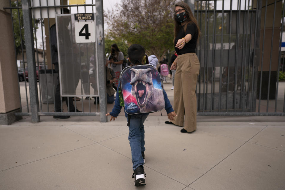 Kindergartener Angel Hernandez leaves after the first day of in-person learning at Maurice Sendak Elementary School in Los Angeles, Tuesday, April 13, 2021. More than a year after the pandemic forced all of California's schools to close classroom doors, some of the state's largest school districts are slowly beginning to reopen this week for in-person instruction. (AP Photo/Jae C. Hong)