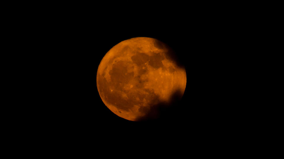 Ein orange- und rosafarbener Erdbeervollmond über Charlotte, North Carolina, gesehen von Kevin McCarthy.