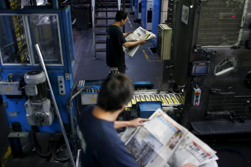 Press operators inspect the print quality at the Apple Daily newspaper, published by Next Media Ltd 's printing facility in Hong Kong, China