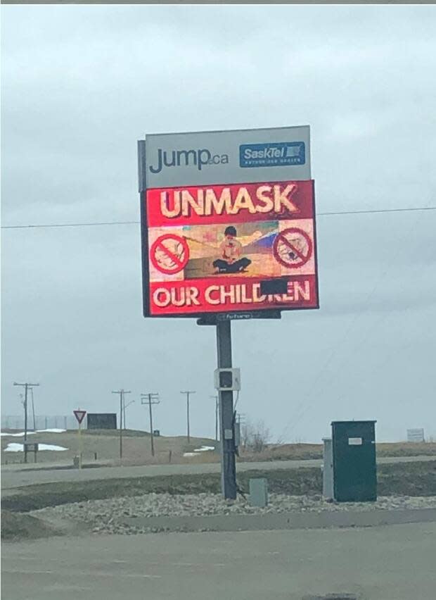 The digital billboard displays four separate messages: one attacks mask-wearing in classrooms, one urges people not to consume COVID-19 news and the other two attack COVID-19 health measures. (Donna Tod/Facebook - image credit)