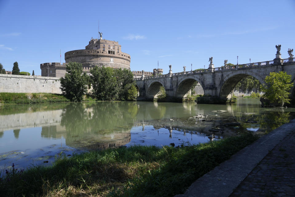 Castel Sant'Angelo is reflected on a partially drought Tiber river bed, in Rome, Monday, Aug. 22, 2022. Italy’s worst drought in 70 years has exposed the piers of an ancient bridge over the Tiber River once used by Roman emperors but which fell into disrepair by the 3rd Century. (AP Photo/Gregorio Borgia)