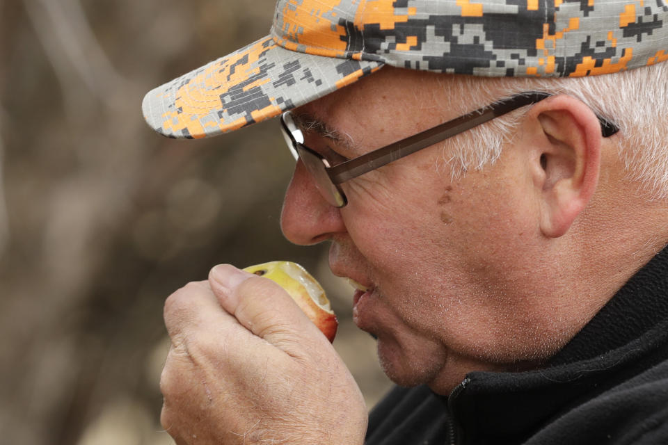 In this Oct. 28, 2019, photo, amateur botanist David Benscoter, of The Lost Apple Project, takes a bite of an apple he picked in an orchard at a remote homestead near Pullman, Wash. Benscoter and fellow botanist E.J. Brandt have rediscovered at least 13 long-lost apple varieties in homestead orchards, remote canyons and windswept fields in eastern Washington and northern Idaho that had previously been thought to be extinct. (AP Photo/Ted S. Warren)