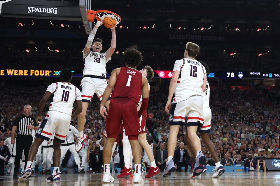 GLENDALE, ARIZONA - APRIL 06: Donovan Clingan #32 of the Connecticut Huskies dunks the ball in the second half against the Alabama Crimson Tide in the NCAA Men's Basketball Tournament Final Four semifinal game at State Farm Stadium on April 06, 2024 in Glendale, Arizona. (Photo by Jamie Squire/Getty Images)