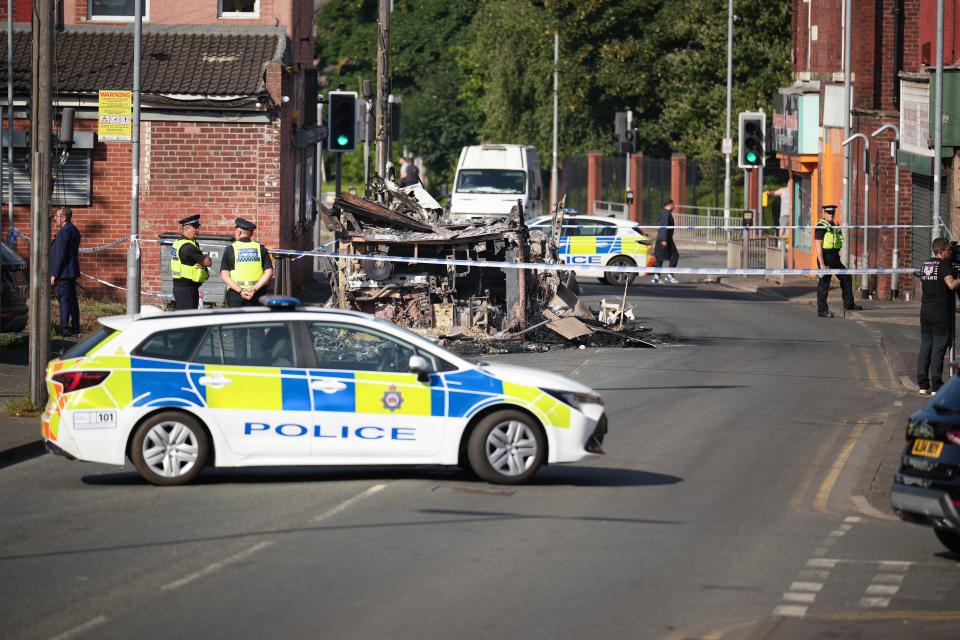 Police tape cordons off the remains of a burnt out bus after disturbance last night (Getty Images)