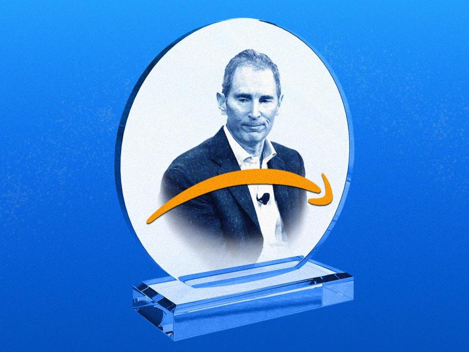 Amazon CEO Andy Jassy is depicted on a glass trophy, with the Amazon logo forming a frown in front of him.