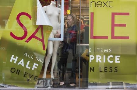 A shop assistant creates a window display in a Next store in central London December 30, 2014. REUTERS/Neil Hall