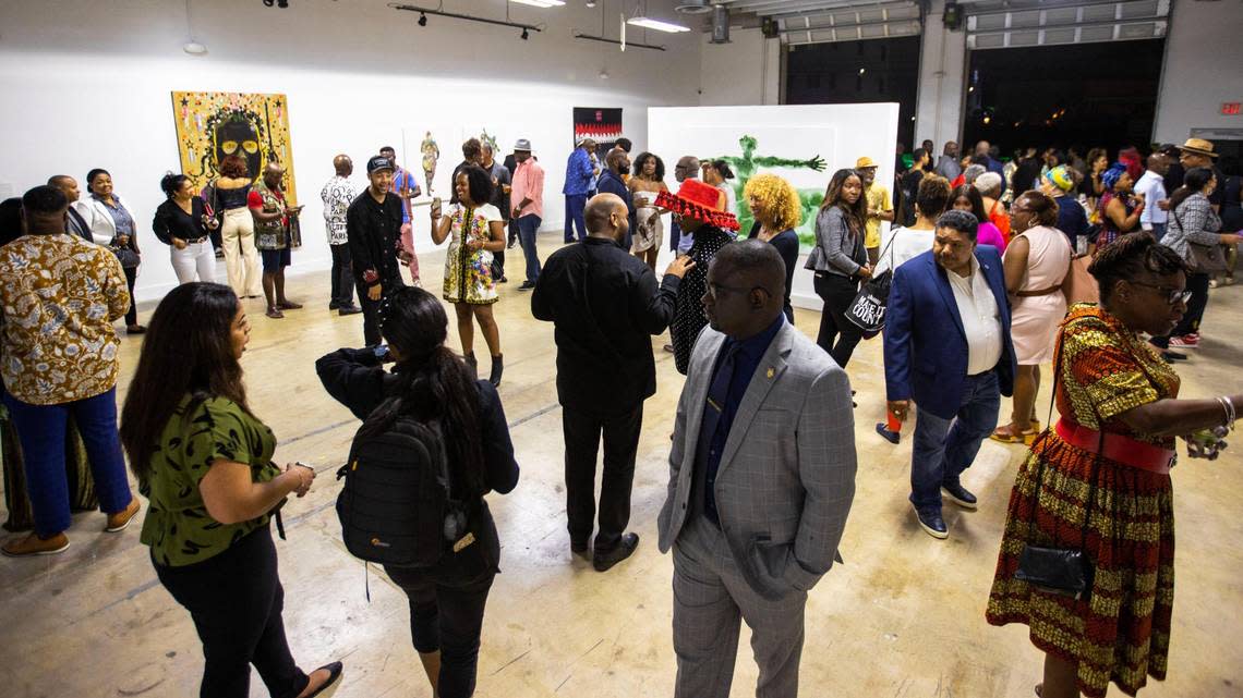 People socialize and view artwork during the Preview for The Art of Transformation event at The ARC and Logan Building in Opa-locka, Florida, on Wednesday, November 30, 2022.