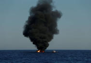 A rubber dinghy is burnt and sunk after the migrants on board were rescued by the Malta-based NGO Migrant Offshore Aid Station (MOAS) in the central Mediterranean in international waters some 15 nautical miles off the coast of Zawiya in Libya, April 14, 2017. REUTERS/Darrin Zammit Lupi