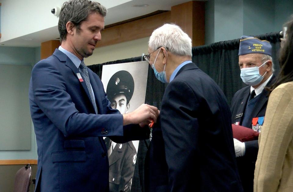 French Consul General in New York Jérémie Robert pins the insignia of the French Legion of Honor on World War II veteran and retired United States Army Private First Class Edward L. Chan during a ceremony at Brookdale Community College Wednesday, April 6, 2022.