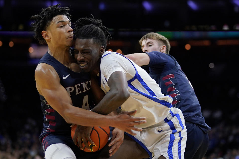 Kentucky's Aaron Bradshaw, center, battles for the ball against Pennsylvania's Tyler Perkins, left, and Sam Brown during the second half of an NCAA college basketball game, Saturday, Dec. 9, 2023, in Philadelphia. (AP Photo/Matt Slocum)