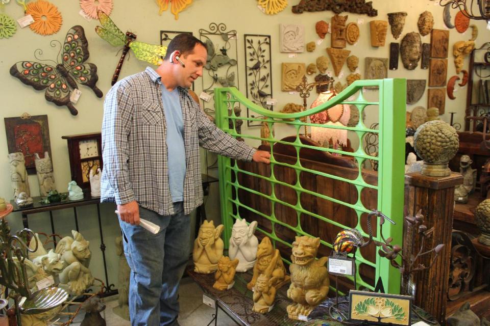 In this May 19, 2012 photo, Jim Honold, the owner of Home & Garden Art in Seattle, points out his hand-crafted modern gate, among a room of sculptures and outdoor art. Honold recommends an artistic gate to reflect personality and set the tone for the rest of the house. (AP Photo/Cedar Burnett)