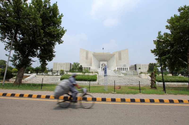 A man rides a bicycle past the Supreme Court building in Islamabad