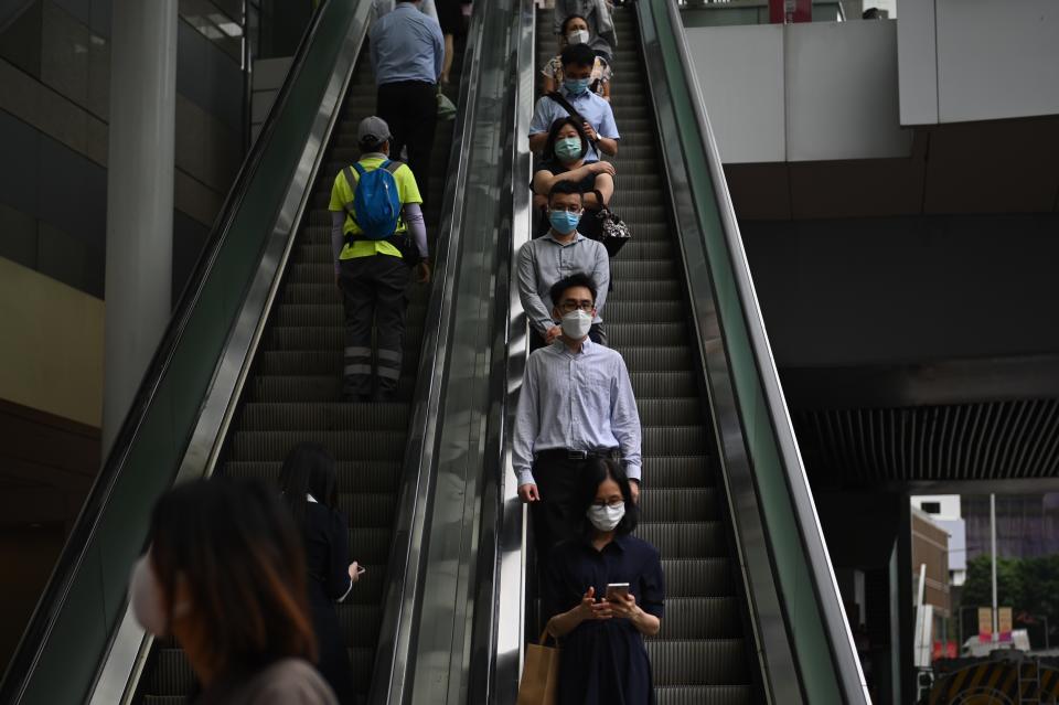 Office Workers and Pedestrian riding on an escalator near the Central Government Office on July 5, 2022 in Hong Kong, China. The Hong Kong Government will increase the Salary of all Civil Servant by 2.5%, down from the original 7.26% for high Level Civil Servant, 4.55% for Mid Level Colvin Servant and 2.04% for Low Level Civil Servant proposed increase. (Photo by Vernon Yuen/NurPhoto via Getty Images)