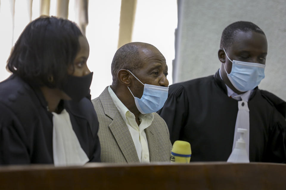 Paul Rusesabagina, center, whose story inspired the film "Hotel Rwanda", appears at the Kicukiro Primary Court in the capital Kigali, Rwanda Monday, Sept. 14, 2020. A Rwandan court on Monday charged Paul Rusesabagina with terrorism, complicity in murder, and forming an armed rebel group, while Rusesabagina declined to respond to all 13 charges, saying some did not qualify as criminal offenses and saying that he denied the accusations when he was questioned by Rwandan investigators. (AP Photo/Muhizi Olivier)