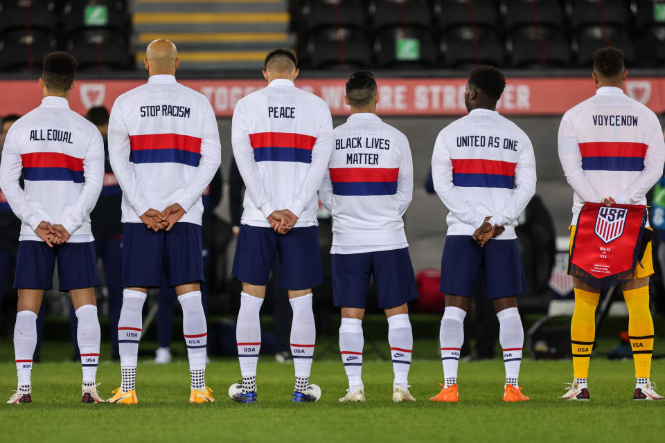 SWANSEA, WALES - NOVEMBER 12:  Players of United States of America line up for the national anthems with messages on the back of their jackets during the international friendly match between Wales and the USA at Liberty Stadium on November 12, 2020 in Swansea, Wales. Sporting stadiums around the UK remain under strict restrictions due to the Coronavirus Pandemic as Government social distancing laws prohibit fans inside venues resulting in games being played behind closed doors. (Photo by Matthew Ashton - AMA/Getty Images)