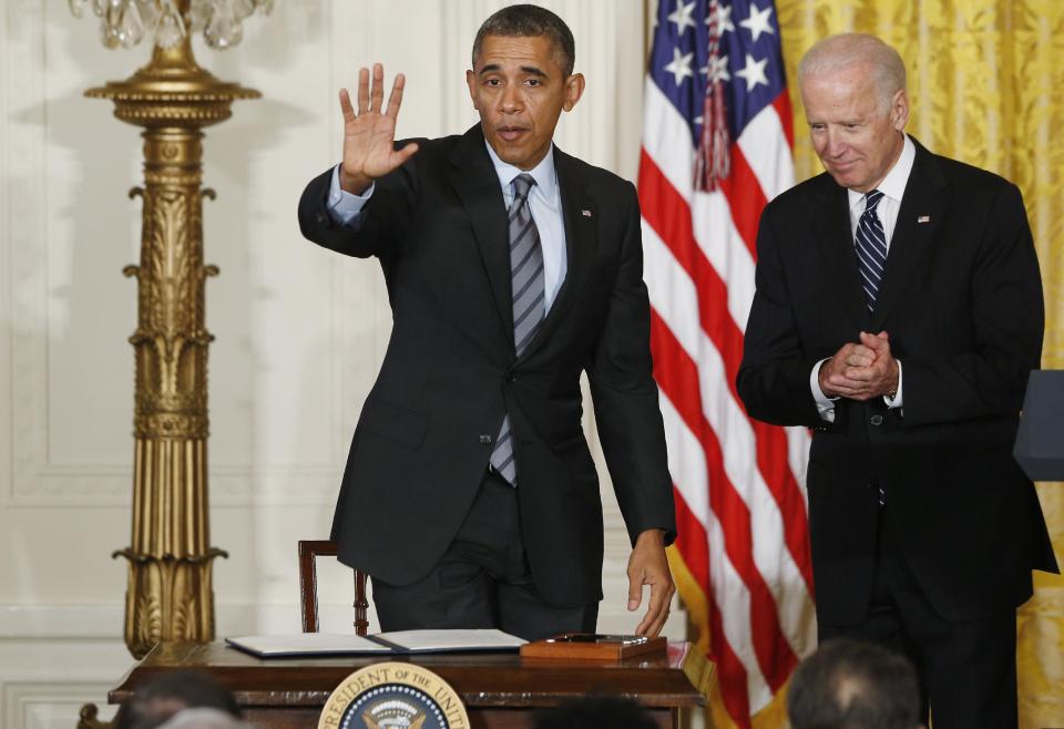 President Barack Obama waves to the audience after he signed a presidential memo directing the federal government not to discriminate against those long-term unemployed workers in its own hiring practices during an event in the East Room at the White House in Washington, Friday, Jan. 31, 2014. Vice President Joe Biden is at right. (AP Photo/Charles Dharapak)