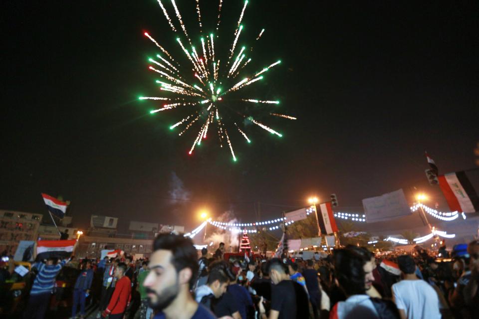 Anti-government protesters celebrate a soccer match win in Tahrir Square in Baghdad, Iraq, Thursday, Nov. 14, 2019. Iraqis are celebrating a 2-1 win over Iran in a much-anticipated World Cup qualifying match. (AP Photo/Hadi Mizban)