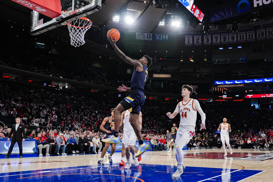 Marquette guard Kam Jones (1) drives to the basket ahead of St. John's forward Brady Dunlap (44) during the first half of an NCAA college basketball game in New York, Saturday, Jan. 20, 2024. (AP Photo/Peter K. Afriyie)